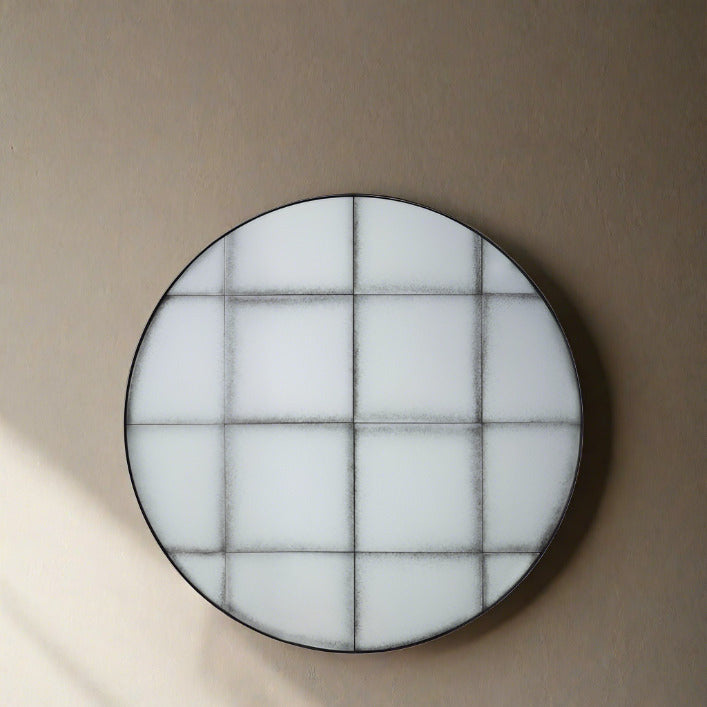 Baxter medium antiqued round wall mirror with grid detail in a structural metal outer frame | malletandplane.com