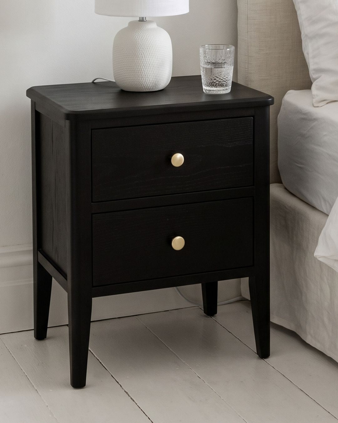 Alvar Black Two Drawer Bedside Table with gold handles and raised base