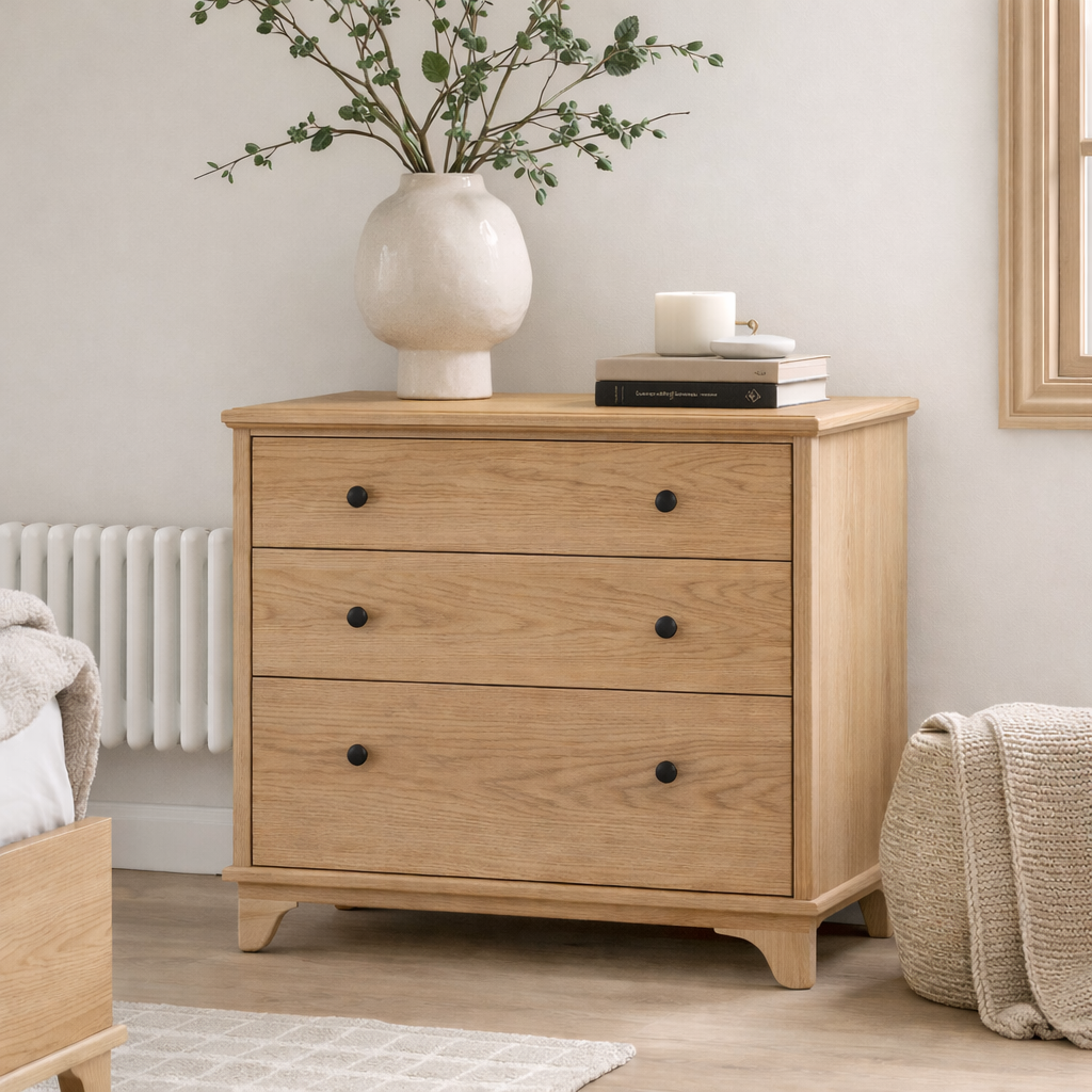 Modern compact oak chest of drawers with three drawers in a neutral bedroom setting